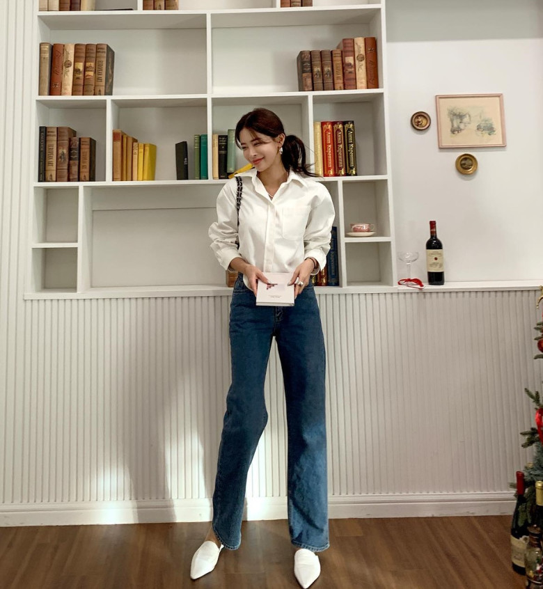 Sơ mi trắng sơ vin tôn vòng eo, trong khi quần jeans ống đứng cạp cao tạo hiệu ứng chân dài miên man – một combo chuẩn chỉnh cho nàng công sở hiện đại.
