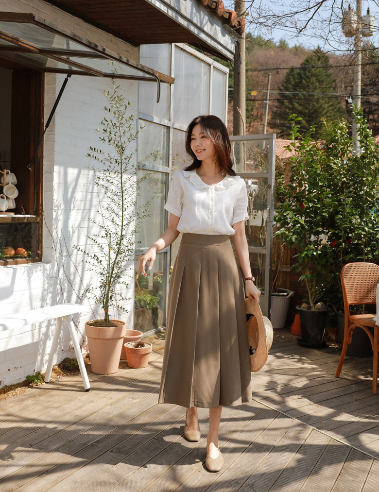 Chiếc áo blouse ngắn tay được sơ vin gọn gàng kết hợp cùng chân váy dài cạp cao giúp kéo dài phần chân một cách tự nhiên, tạo cảm giác cao ráo và đầy thanh thoát cho người mặc.