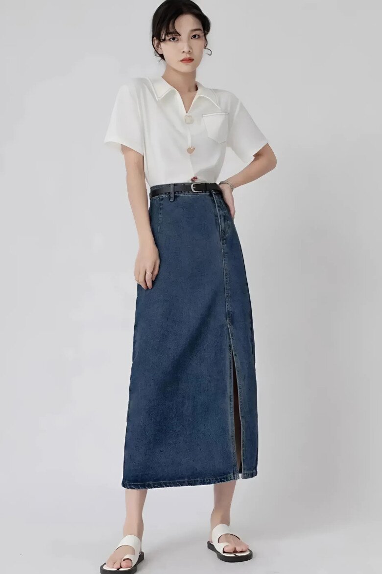 Sự kết hợp tối giản giữa áo sơ mi trắng cùng chân váy denim dài xẻ tà mang đến vẻ đẹp thanh lịch, hiện đại.