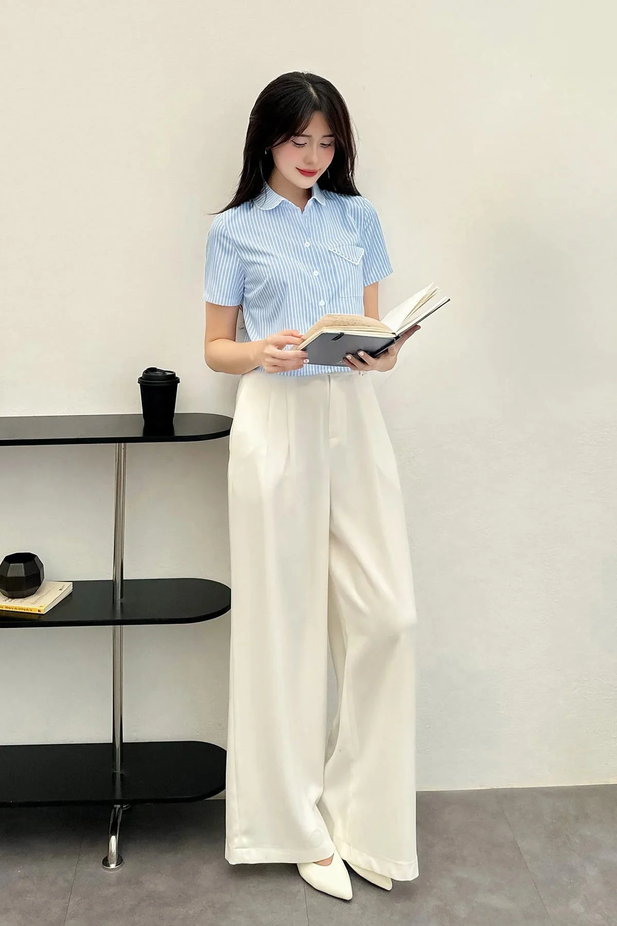 Sự kết hợp thanh lịch giữa sơ mi sọc xanh pastel và quần ống rộng trắng mang đến vẻ ngoài nhẹ nhàng, tinh tế.