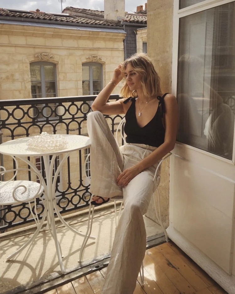 Tinh tế và đầy chất thơ, outfit với áo hai dây đen và quần linen ống rộng nude mang lại cảm giác nhẹ nhàng, bay bổng.