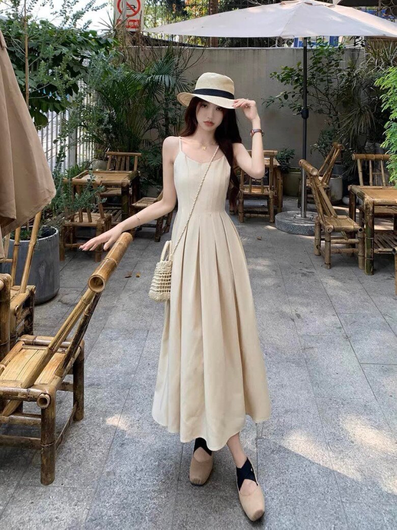 Phong cách nàng thơ lên ngôi với váy maxi hai dây màu kem, tôn dáng nhẹ nhàng và thanh lịch.