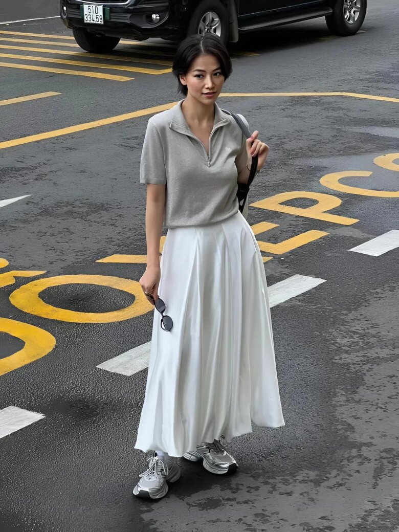 Chiếc áo polo xám chất liệu thun mỏng kết hợp cùng chân váy trắng xòe tạo nên tổng thể thanh lịch mà phóng khoáng.