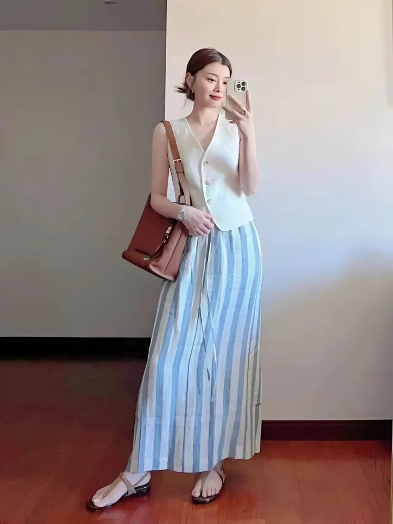 Áo ghi-lê vải lanh dáng ôm kết hợp chân váy maxi sọc xanh – trắng tạo nên vẻ đẹp thanh thoát, nền nã.