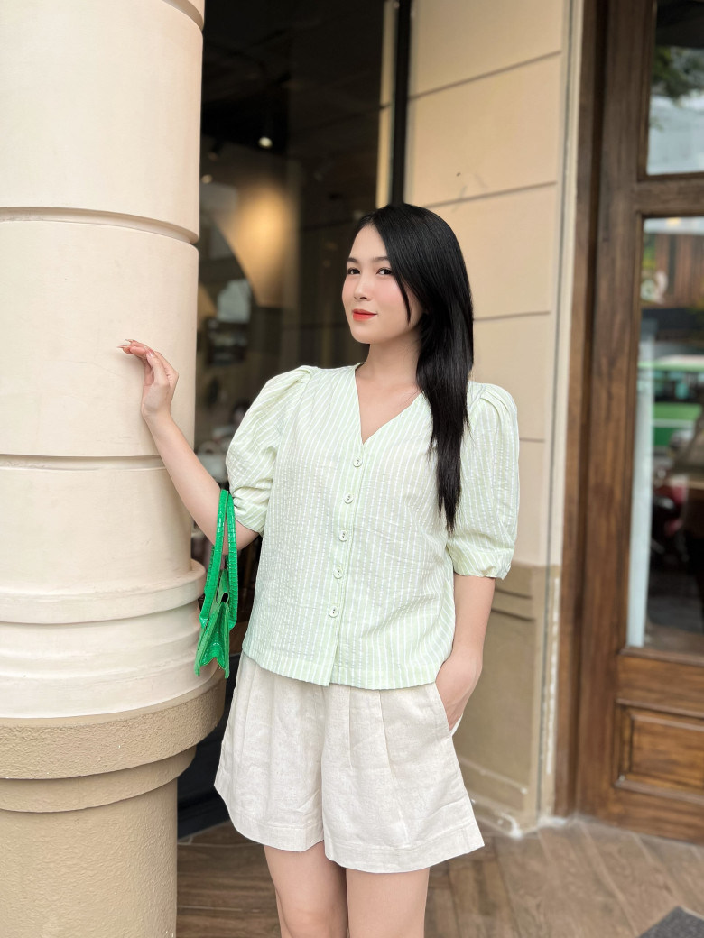 Phong cách nữ tính và thanh lịch với áo blouse tay bồng vải lanh kẻ sọc pastel, kết hợp quần short đồng chất liệu tạo tổng thể nhẹ nhàng, dễ chịu.