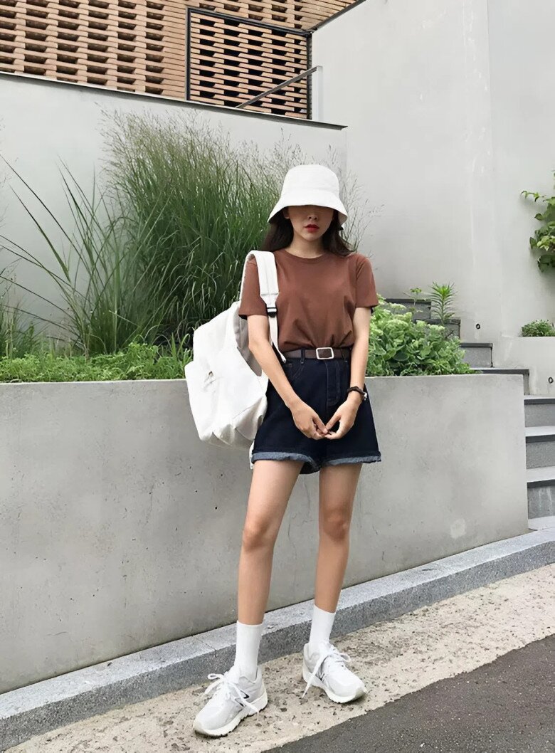Phong cách casual Hàn Quốc với áo thun nâu, quần short denim tối màu và sneaker trắng. 