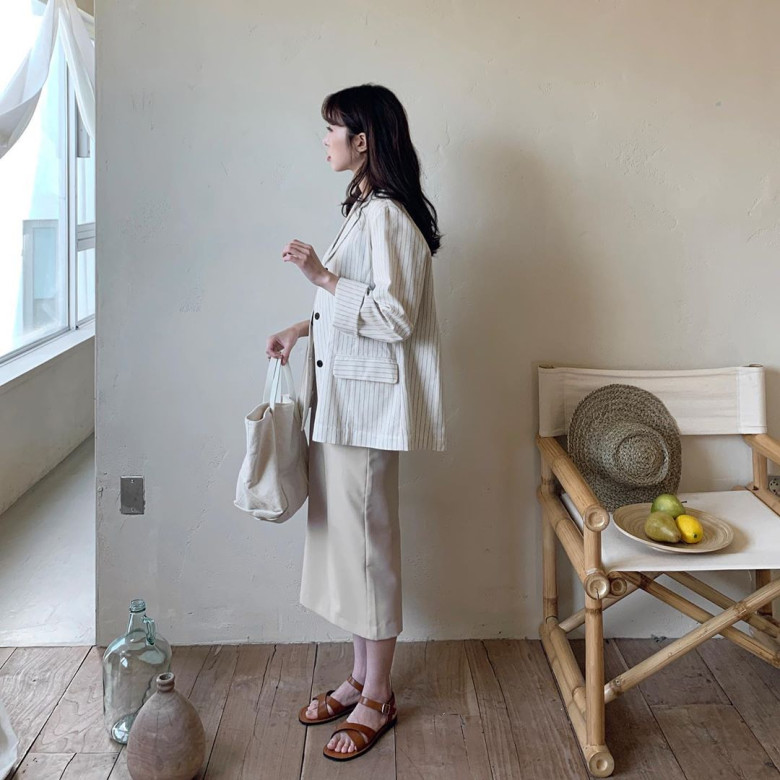 Sự kết hợp thanh lịch giữa blazer kẻ sọc và váy dáng ôm màu beige tạo nên phong thái cổ điển, tối giản mà vẫn đầy tinh tế.