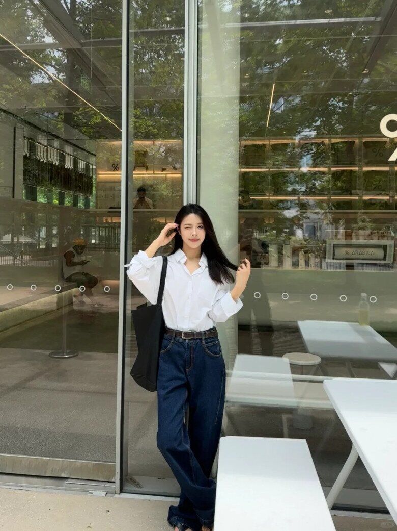 Với áo sơ mi trắng cổ điển kết hợp quần jeans xanh đậm cạp cao, cô nàng mang đến vẻ ngoài thanh lịch pha chút phóng khoáng.