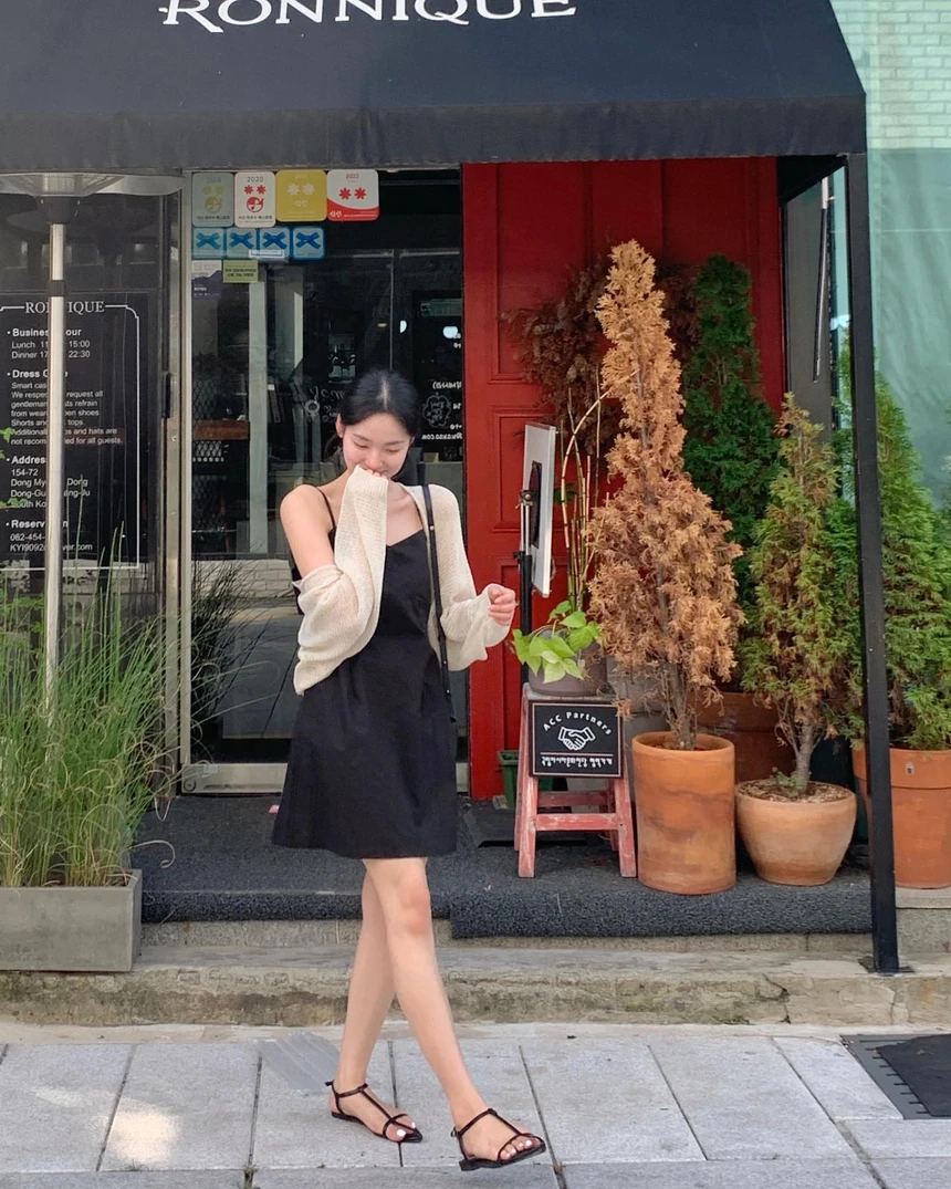Váy 2 dây đen dáng ngắn mix cùng cardigan lưới mỏng tạo nên vẻ ngoài ngọt ngào mà không kém phần cá tính.