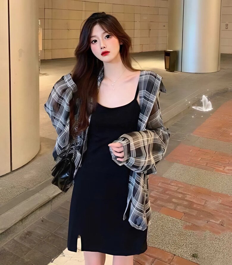 Đầm hai dây đen tối giản kết hợp sơ mi caro oversized mang đến vẻ phóng khoáng, năng động.