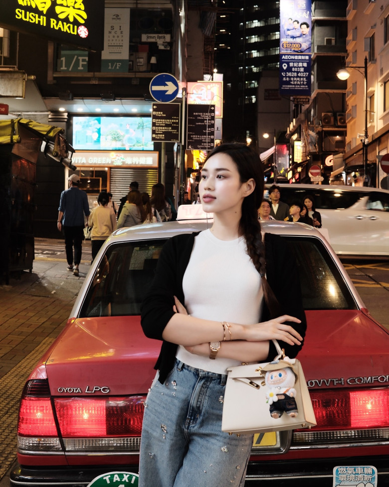 Diện áo trắng ôm sát kết hợp cùng cardigan đen nhẹ và quần jeans đính đá, cô nàng toát lên khí chất thời thượng giữa phố đêm Hong Kong.