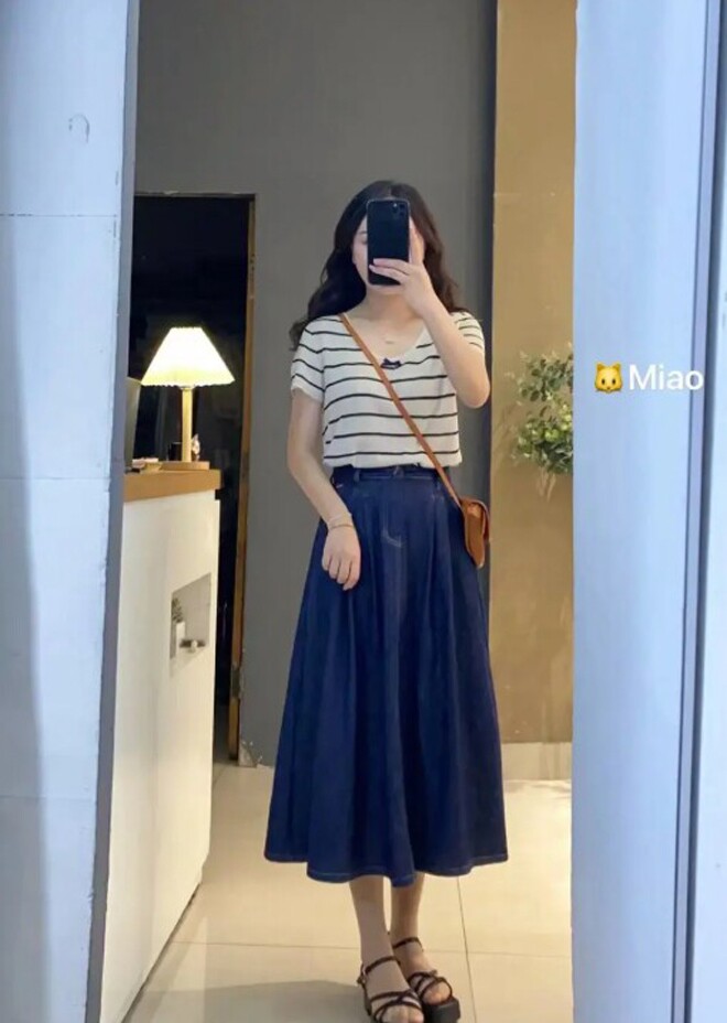 Sự kết hợp giữa áo thun kẻ sọc và chân váy denim xanh navy mang đến vẻ đẹp retro hiện đại.