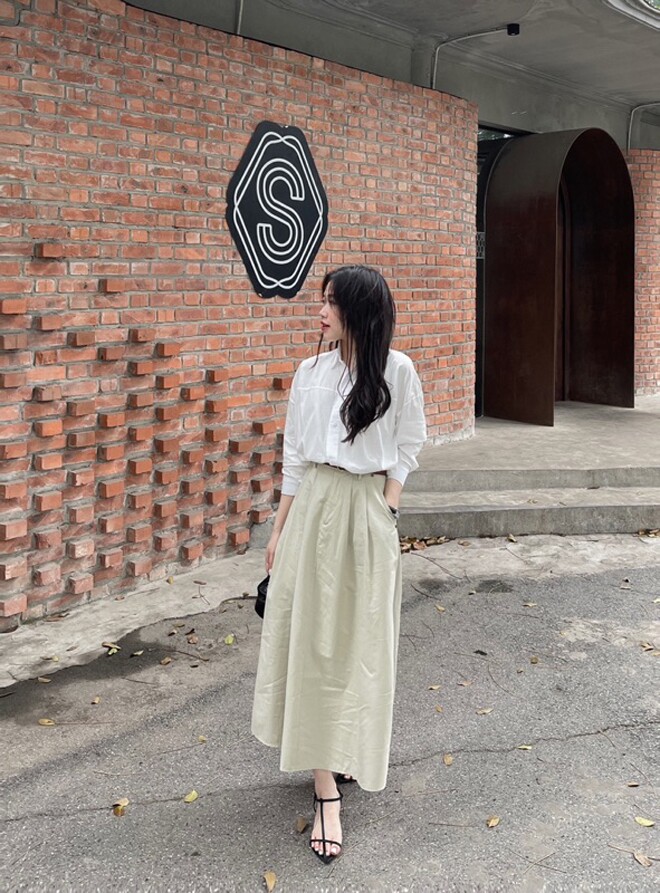 Áo sơ mi trắng buông nhẹ và chân váy dáng dài tạo nên vẻ ngoài thanh lịch, đậm chất Hàn.