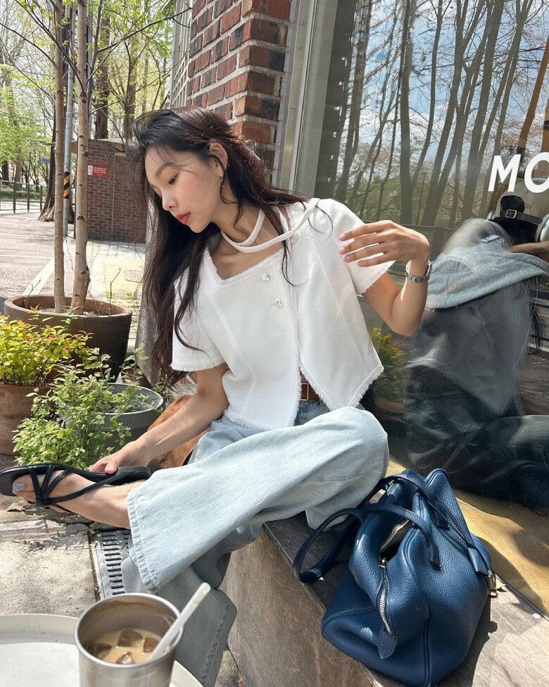 Sự kết hợp giữa áo blouse trắng vải tweed mỏng nhẹ với đường viền tua rua tinh tế cùng quần jeans ống rộng sáng màu mang đến hình ảnh một quý cô hiện đại nhưng không kém phần mềm mại. 