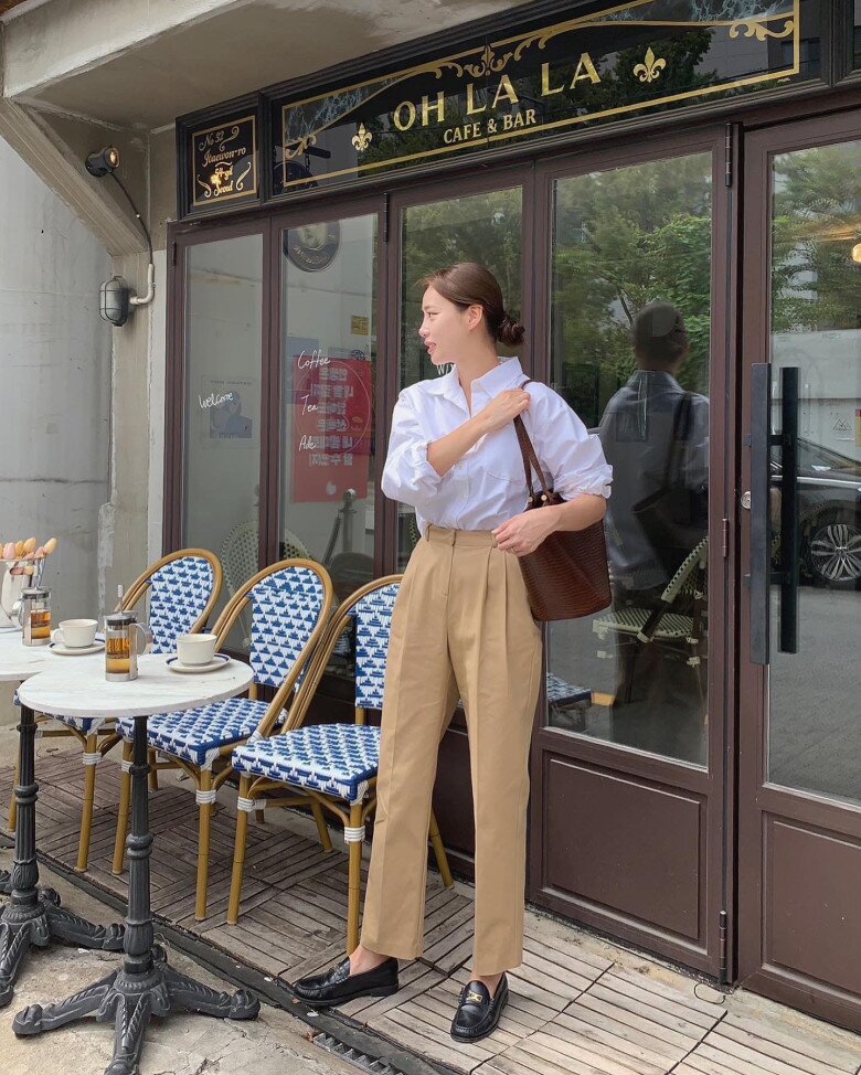Áo sơ mi trắng cổ điển kết hợp với quần ống đứng màu nâu trà sữa tạo nên set đồ vừa tinh gọn vừa tinh tế.