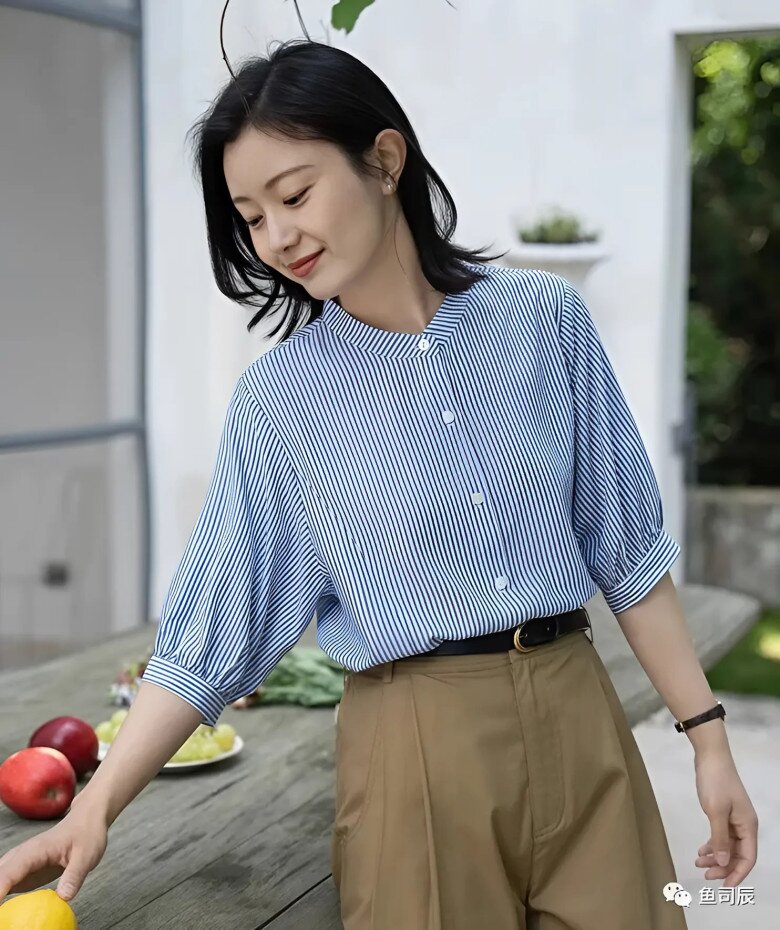 Chiếc áo sơ mi sọc xanh trắng nhẹ nhàng kết hợp cùng quần tông nâu trà sữa mang đến cảm giác mát mẻ, thanh lịch. Tông xanh lạnh hoà quyện với sắc nâu nhạt, tạo nên bảng màu dịu mắt, lý tưởng cho những ngày hè thư thái.