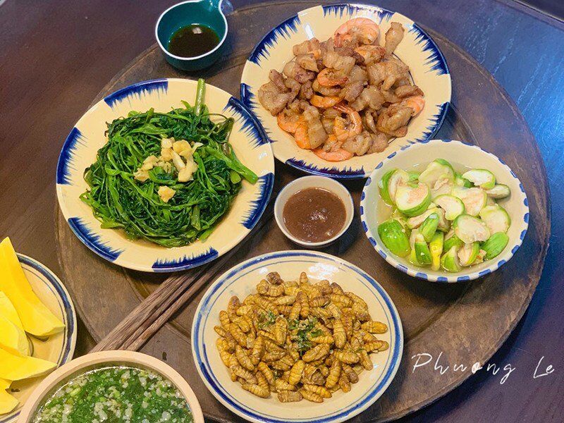 Mâm cơm này gồm: Nhộng rang lá chanh, rau muống xào tỏi, thịt rang tôm, cà dừa muối xổi, canh rau thịt băm. (Ảnh: Thùy Phương).