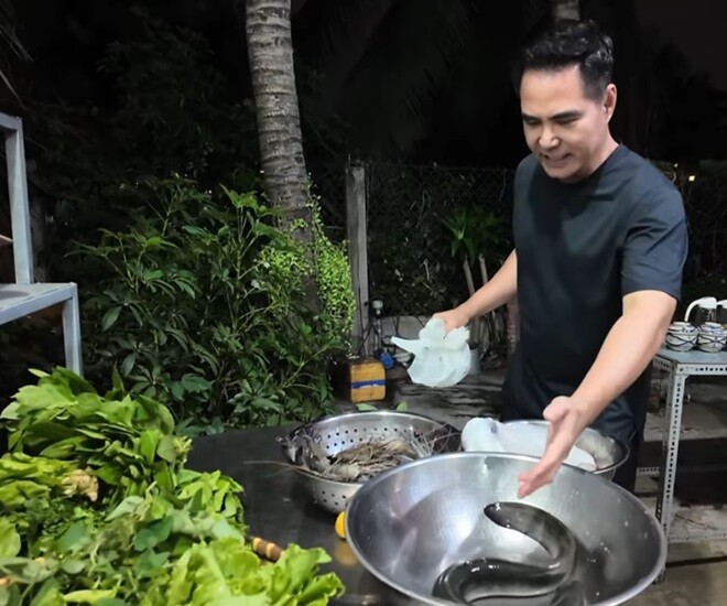 Diễn viên Trung Dũng chuẩn bị nguyên liệu cho bữa BBQ tại sân vườn nhà. Trên bàn là cá trình tươi sống, tôm sú, rau thơm các loại như xà lách, ngò, lá cóc... Anh rất hào hứng với món ăn ngon ngất ngây.