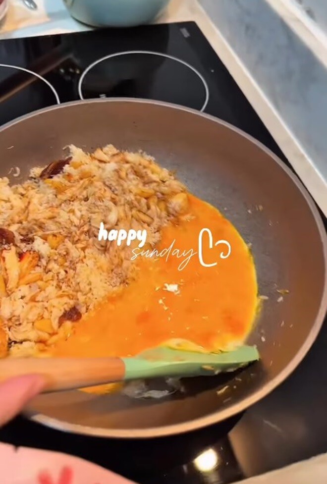 Trứng gà được đánh tan, đổ trực tiếp vào hỗn hợp cơm – cua trên chảo, tạo màu vàng bắt mắt và tăng độ béo ngậy cho món ăn.