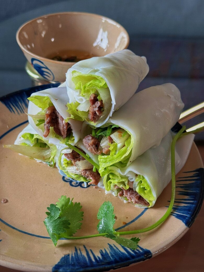 Còn thường ngày, người đẹp 35 tuổi được chồng chăm sóc rất chu đáo. “Đi làm về đói bụng muốn xỉu mà phải đợi đầu bếp cuốn từng cuốn phở tỉ mỉ” – Diễm Hương viết. Phở cuốn nhà làm, lớp bánh mềm mịn ôm trọn thịt bò và rau sống, ăn kèm nước mắm chua ngọt trông rất hấp dẫn.