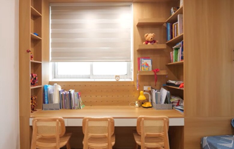 Bàn học của các bé lắp đặt sát cửa sổ giúp tận dụng ánh sáng tự nhiên, kèm theo giá sách âm tường cực kỳ gọn gàng.