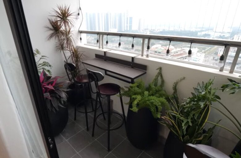 Một góc thư giãn ngoài trời được trồng nhiều cây xanh, có bàn ghế cao và dây đèn, lý tưởng cho những buổi chiều nhâm nhi café ngắm phố.