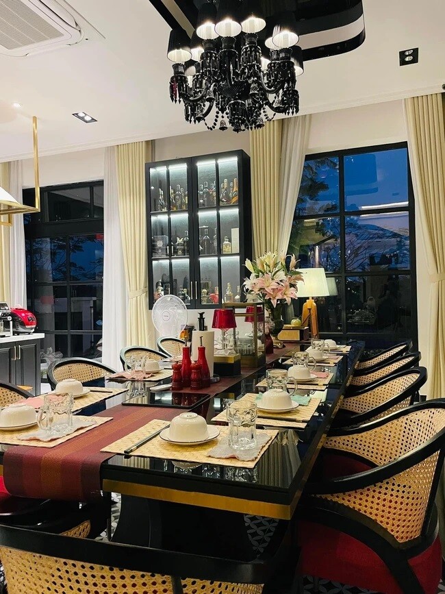 Trong căn biệt thự, nội thất được thiết kế theo phong cách sang trọng. Phòng ăn với bàn lớn, đèn chùm đen cổ điển, đồ dùng bài trí ngăn nắp, thể hiện gu thẩm mỹ tinh tế của chủ nhân.