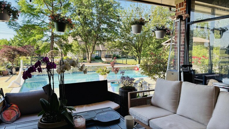 Một góc thư giãn với bộ sofa ngoài trời màu kem, bên cạnh là nhiều giỏ hoa treo lơ lửng. Từ đây, Hồng Ngọc có thể ngắm nhìn khu vườn và hồ bơi trong những buổi sáng thảnh thơi hay chiều mát.