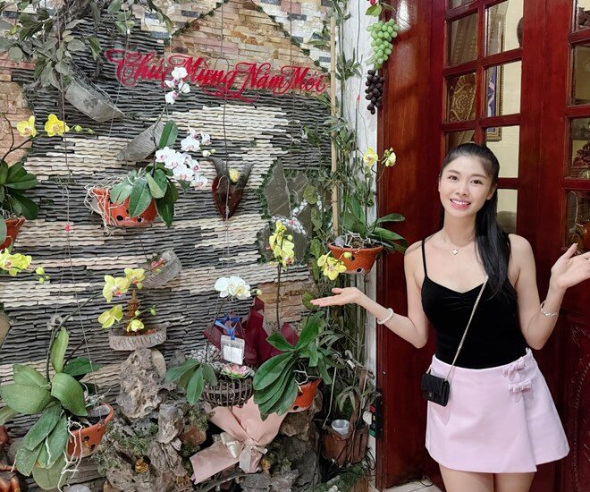 Khu vườn lan trước cửa nhà mẹ vợ Đăng Khôi, với những giò lan vàng và trắng treo dọc bức tường đá trang trí công phu, tạo cảm giác xanh mát và bình yên.