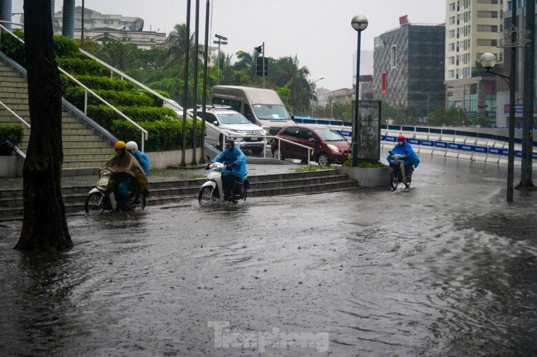 Nhiều xe máy phải rồng rắn leo lên vỉa hè để thoát khỏi chỗ ngập sâu.