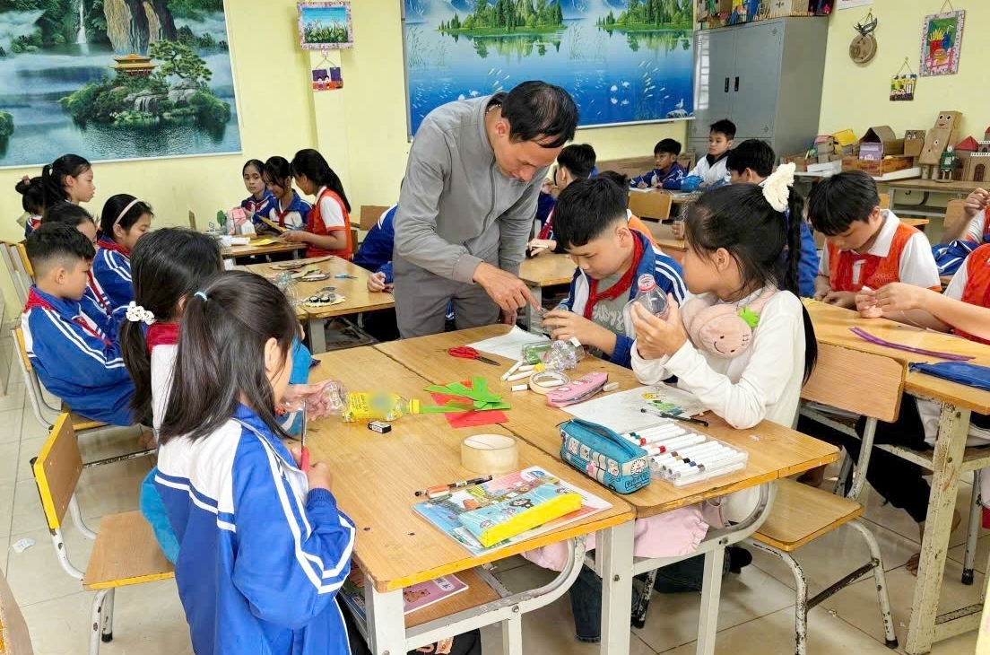 Thầy Khôi chỉ dạy cho các em học sinh sáng tạo những sản phẩm mới từ giấy vụn, rác thải.