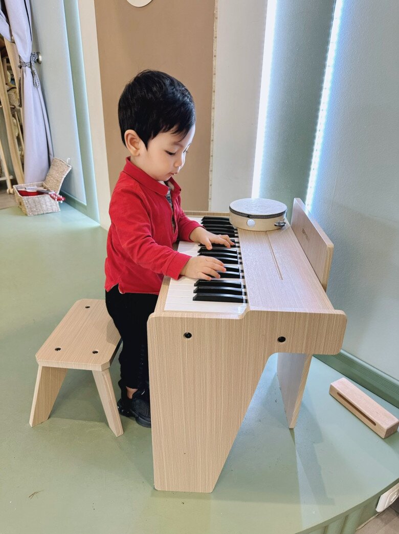 Nhóc tì tỏ ra hứng thú với những nhạc cụ đồ chơi.
