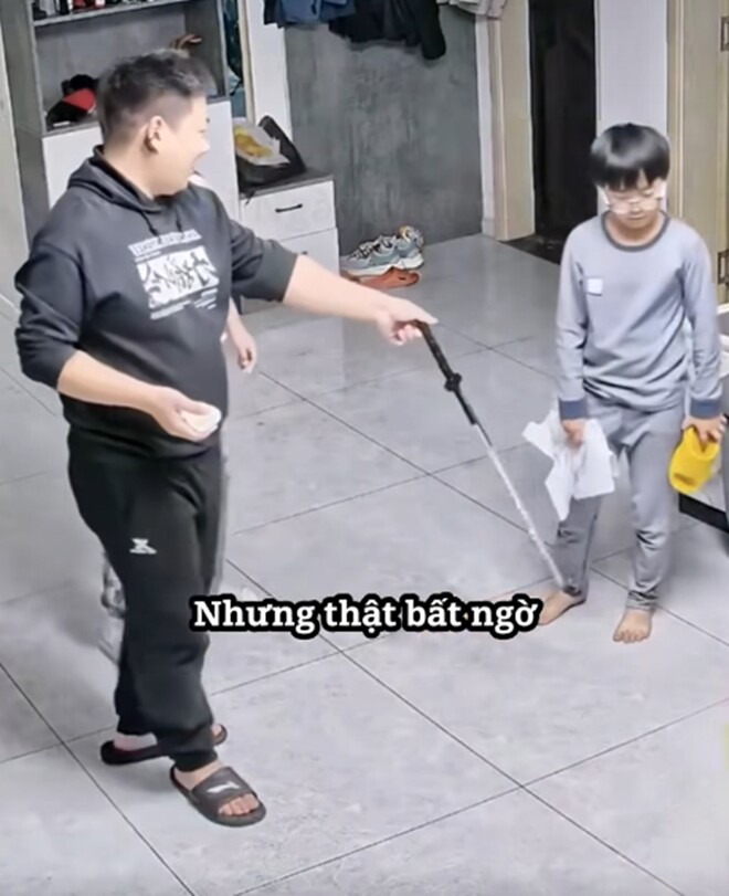 Bố đưa cây gậy để con trai đánh em.