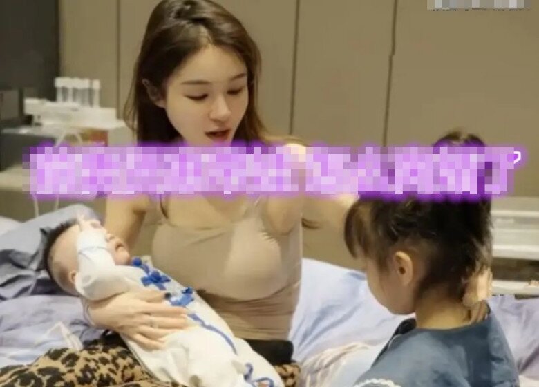 Vợ cũ vừa bế con của vợ mới của chồng, vừa chăm sóc con gái của mình.