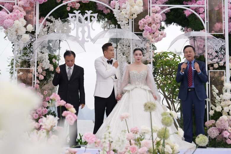 Chú rể chu đáo che ô cho cô dâu trong đám cưới.
