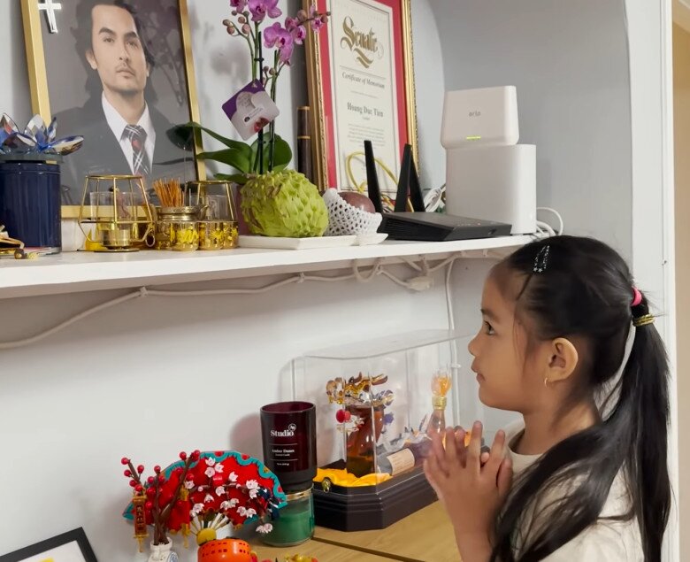 Vợ Đức Tiến đăng tải khoảnh khắc con gái - bé Mèo cầu nguyện trước di ảnh của bố, phủ nhận chuyện không thờ cúng chồng.