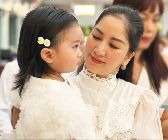 Khánh Thi bế con gái thực hiện lễ rửa tội.