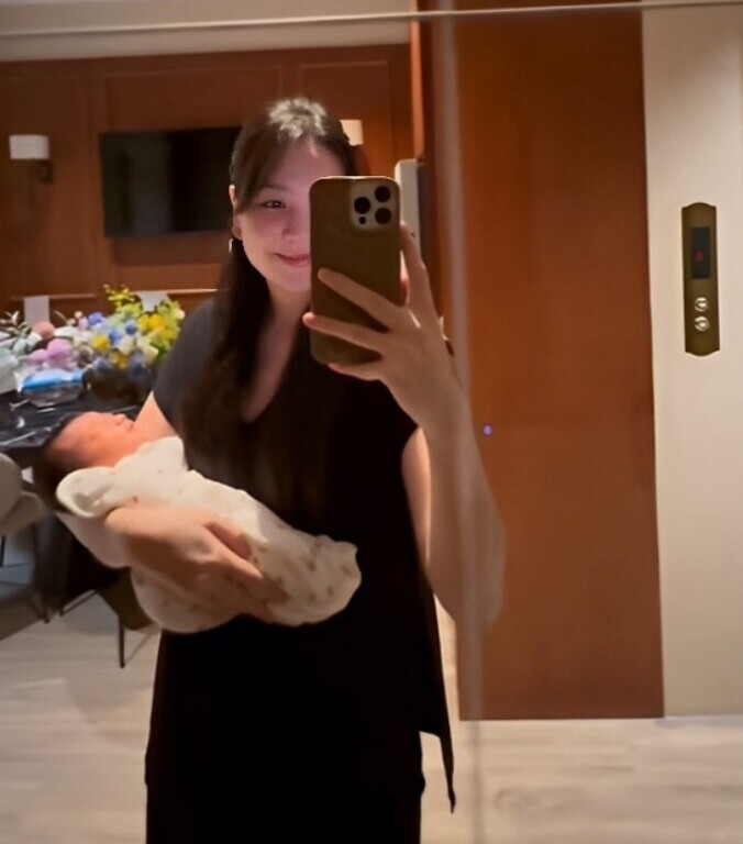 Một tay bế con trai, Mai Ngọc khoe thân hình thon gọn.