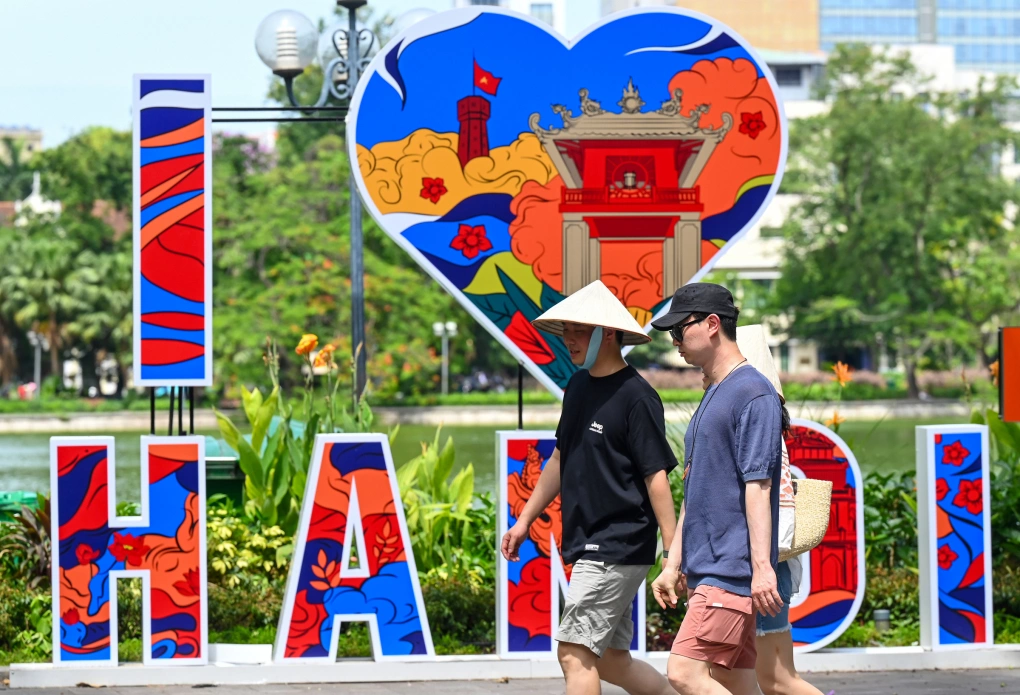 Du khách dạo bộ ở Hà Nội dưới ánh nắng tháng 6. Ảnh: Giang Huy