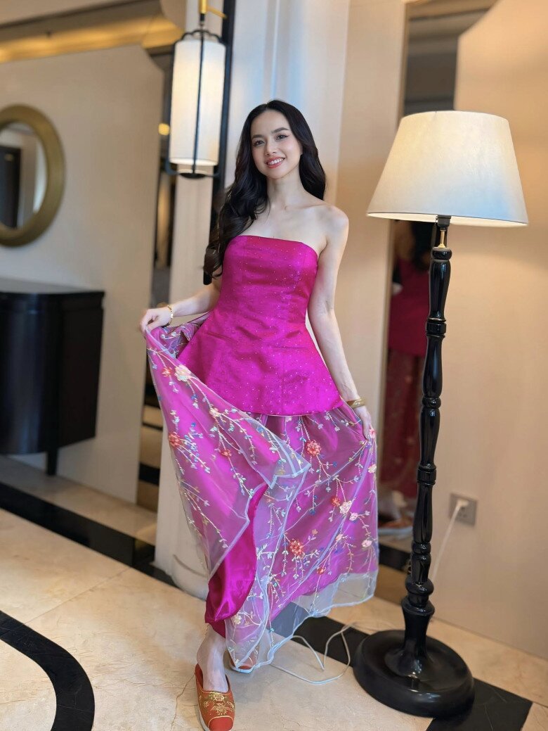 Bộ váy hồng được cách điệu từ trang phục yếm truyền thống của Đinh Ngọc Diệp giúp cô trẻ trung với màu sắc tươi sáng, vừa khéo léo tôn lên phần xương quai xanh quyến rũ. Kết hợp với trang phục váy hồng là mẫu giày thêu hoa độc đáo, làm đậm nét cho chất liệu truyền thống của outfit này 