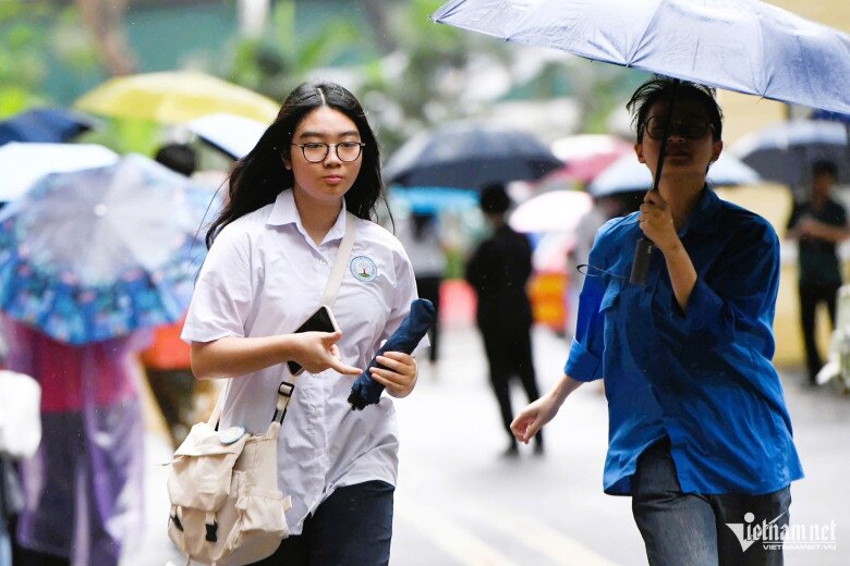 Thí sinh đội mưa đến trường thi sáng 24/5. Ảnh: Thạch Thảo