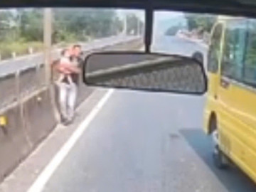 Khoảnh khắc tài xế dừng xe, lao ra bế cháu bé đứng giữa quốc lộ gây xúc động