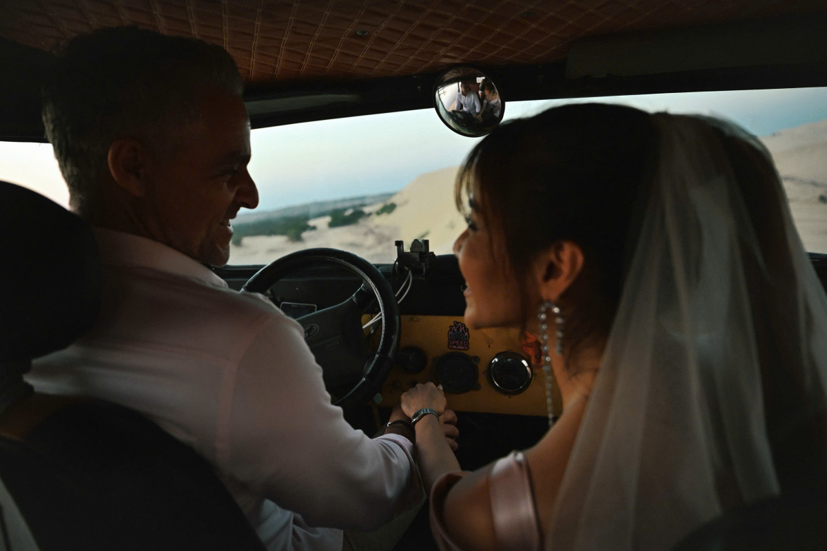 Cô nắm tay vị hôn phu khi đi dạo đồi cát bằng xe jeep.