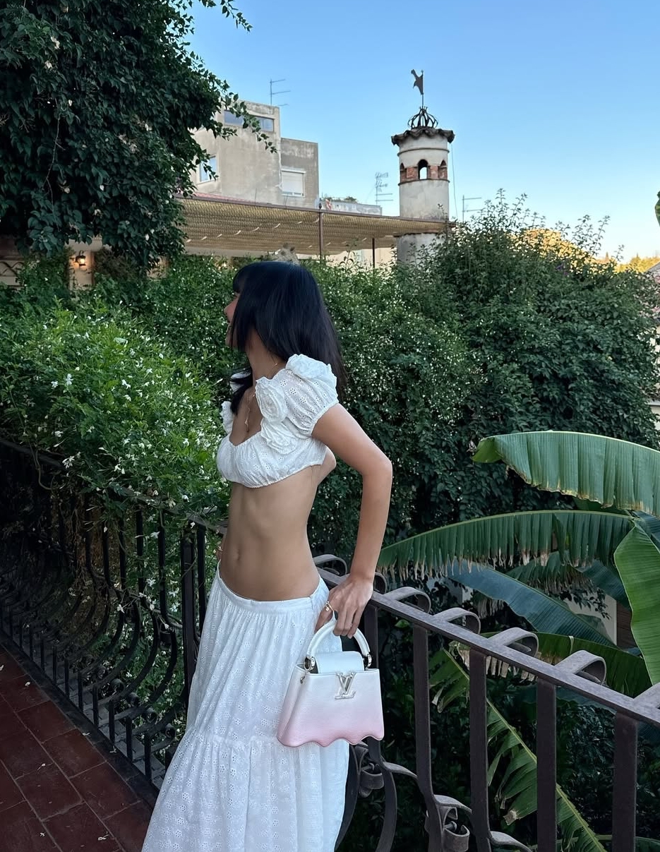 Lisa theo đuổi mốt áo nửa gang tay và chân váy maxi. Túi Louis Vuitton giúp cô tăng vẻ sang trọng.