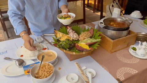 Thực khách thưởng thức món lẩu thả ở dạng nguội bằng cách trộn các nguyên liệu với nước xốt làm từ đậu phộng rang