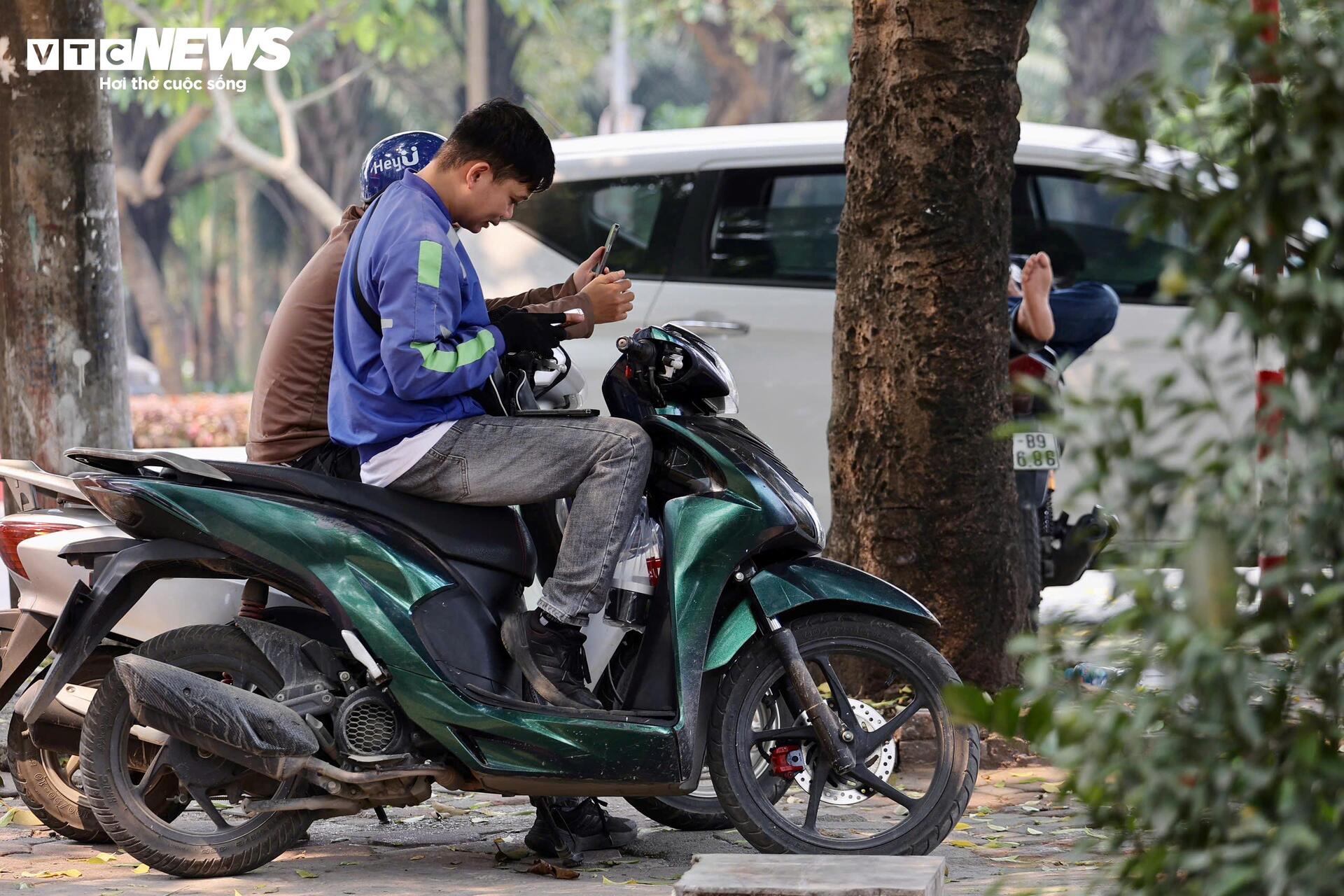 Gầm cầu, chân tòa nhà hay những hàng cây trở thành nơi trú nắng tạm thời của nhiều người đi đường, đặc biệt là lao động tự do.