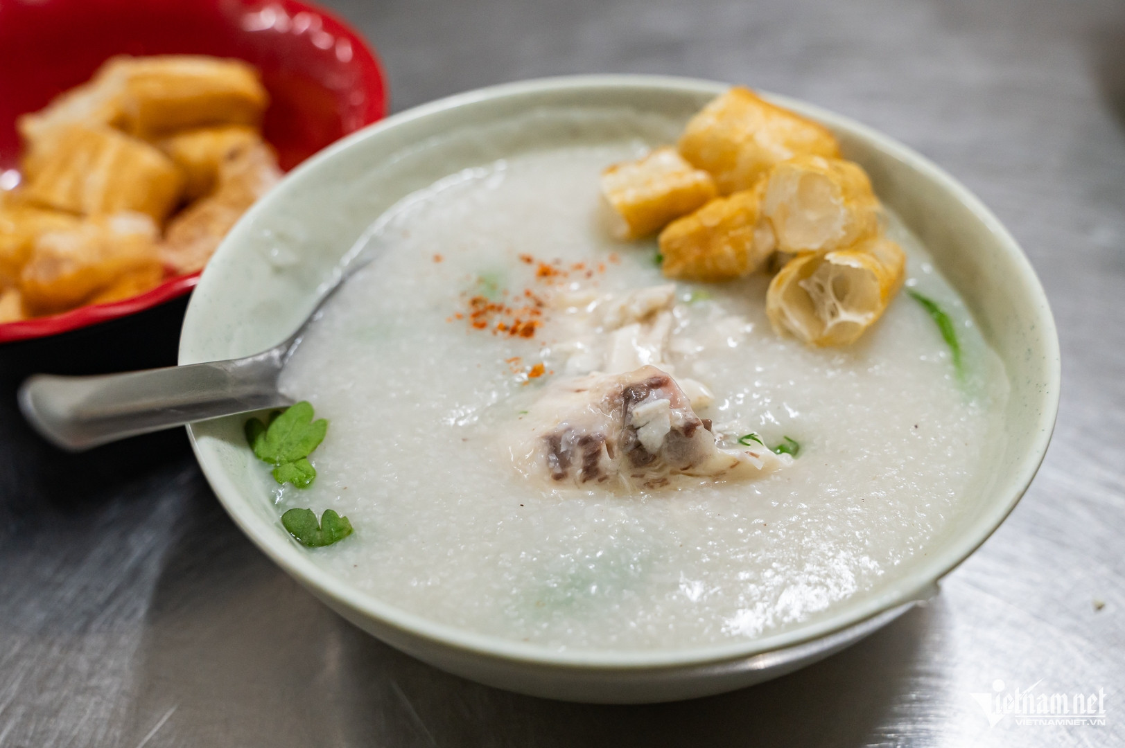 Cháo nóng hổi được cho lên trên thịt cá đã gỡ xương và rau xanh. Ảnh: Nguyễn Huy