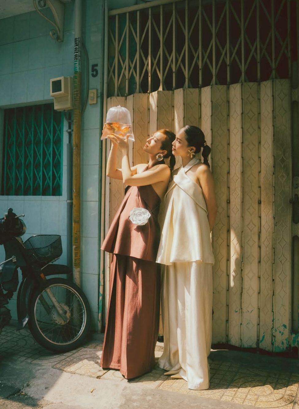 Trước đó vài ngày, cả hai mặc bộ áo yếm giống nhau, chỉ khác màu. Họ để tóc đuôi ngựa, đeo trang sức bản lớn theo phong cách thập niên 1980.