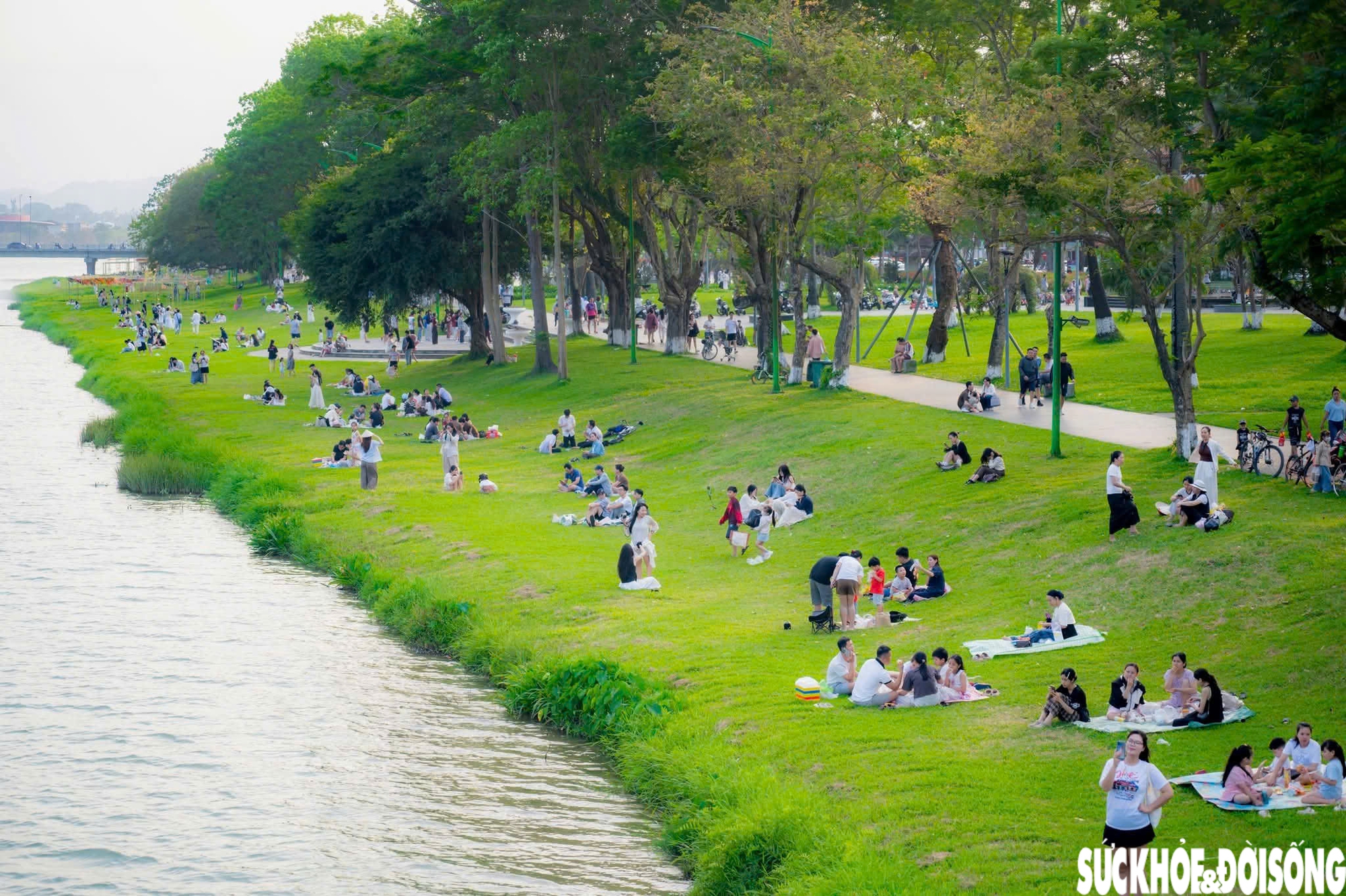 Phía bờ Bắc sông Hương đoạn gần cầu Phú Xuân, không gian bãi cỏ rộng rãi kéo dài trở thành điểm đến lý tưởng cho các nhóm bạn, học sinh, sinh viên tìm đến vui chơi, trò chuyện. Ảnh: Lê Hoàng.