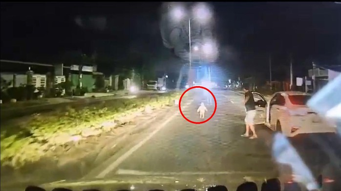 Bé gái chạy ra giữa quốc lộ, được các tài xế kịp thời phát hiện và đưa vào lề an toàn. Ảnh cắt từ clip.